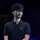 Hideo Kojima smiling onstage.